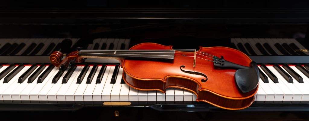 Violin on top of piano keyboard background